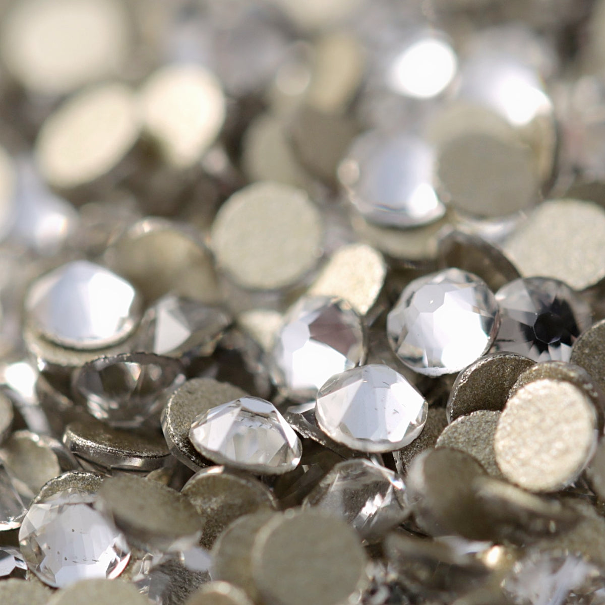 Clear flatback rhinestones with a 16-facet (8+8) cut and metallic foil backs forming a sparkling pile.