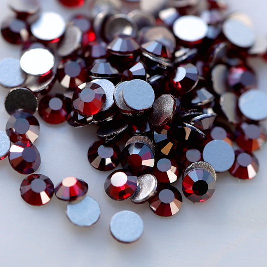 Dark Siam burgundy-red flatback rhinestones with metallic silver shimmer and reflective faceted surface.