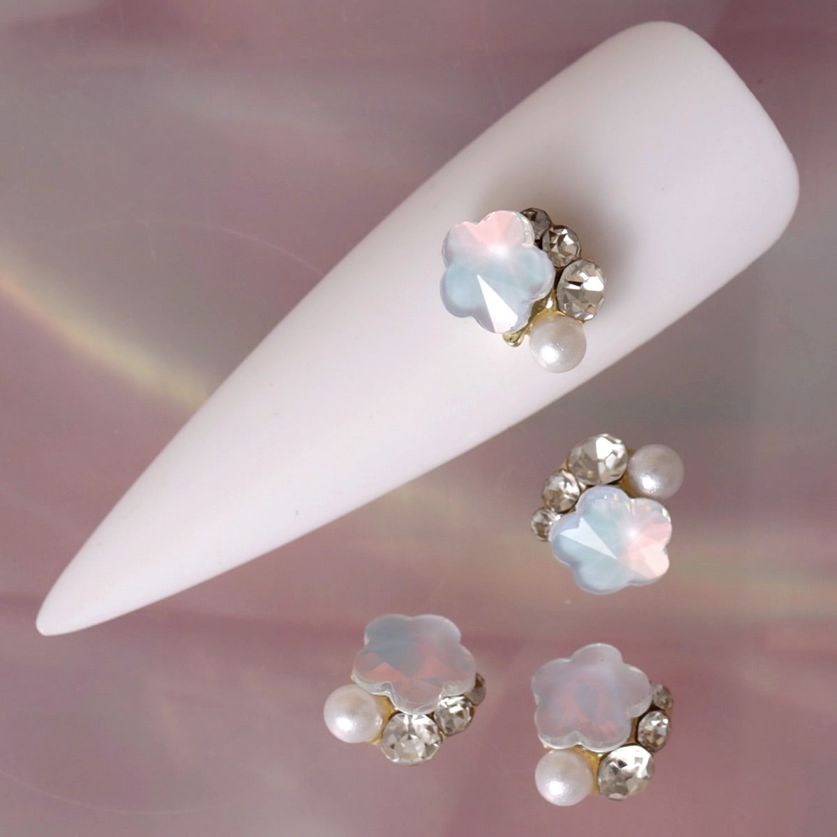 Flower composition nail charm featuring a luminous blue opal flower, faceted clear crystals, iridescent sparkle and a delicate white pearl. This elegant decoration is ideal for bridal manicures, romantic nail art, pastel designs, spring looks and refined accent nails.