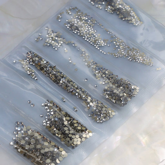 A budget-friendly Crystal glass flatback rhinestone mix containing approximately 1728 clear faceted stones in six separate compartments. The set includes SS3 twice, plus SS4, SS5, SS6 and SS8 rhinestones, making it ideal for practice, detailed nail art, bridal manicures, crystal gradients and everyday sparkling designs.