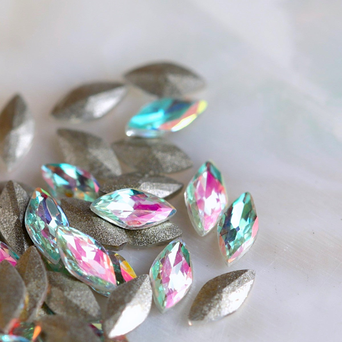Faceted Aqua Pink Iridescent glass navette stones with pale aqua centre, pink shimmer and slightly curved backs.