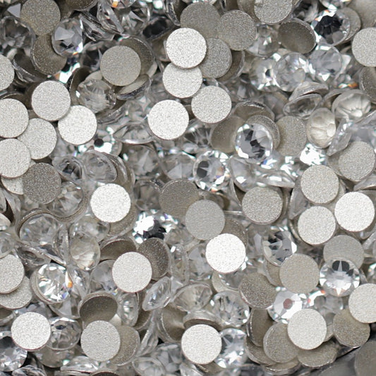 Clear Flatback K9 Crystal rhinestones with faceted tops and metallic foil backs scattered in a sparkling pile.