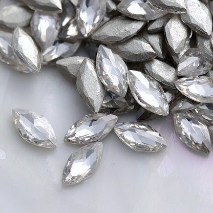 Close-up of sparkling clear marquise-shaped flatback zircon crystals with silver backs, perfect for creating elegant nail designs and crystal patterns