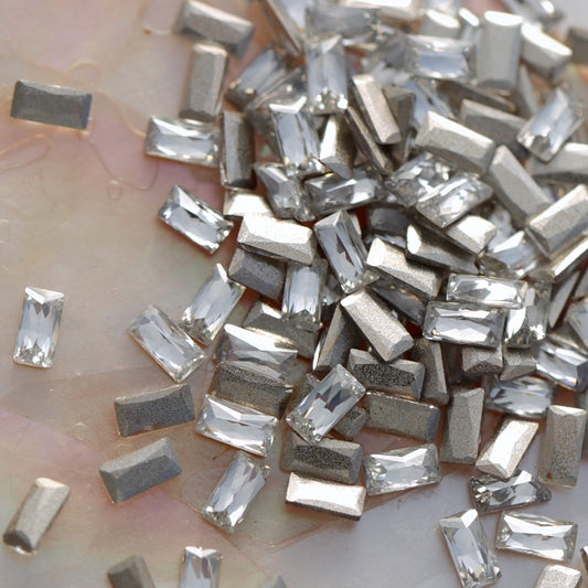 Close-up of silver rectangular beads on a light background