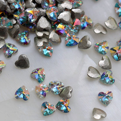 Crystal AB flatback zircon heart nail decorations with clear faceted surfaces and rainbow reflections.