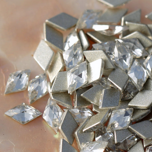 Mix of clear and silver rhombus shaped flatback zircons with high-reflectivity facets for 3D nail decorations