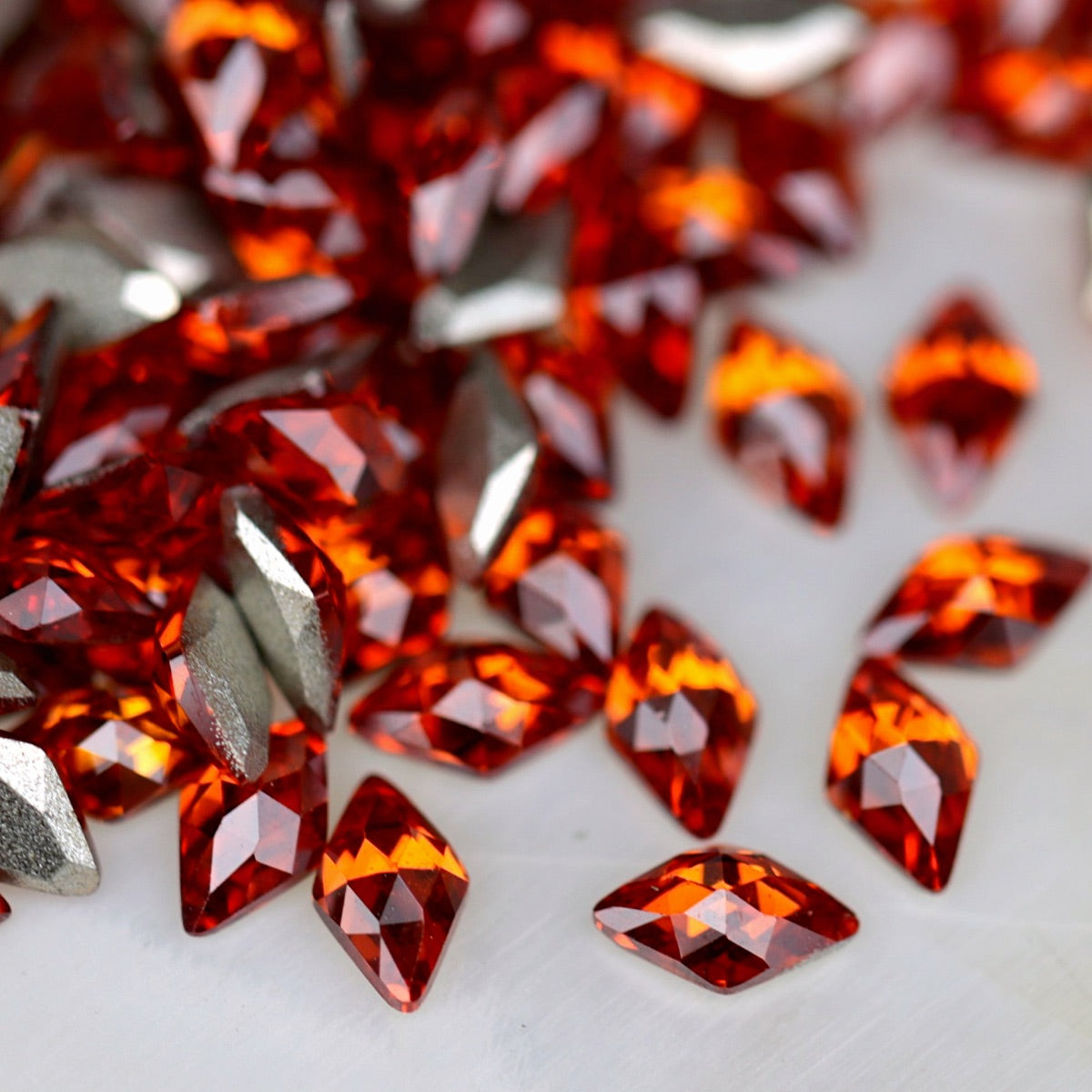 Flatback Zircon Nail Art Rhombus Hyacinth crystals measuring 5×3mm with vivid orange-red, coral and amber reflections.