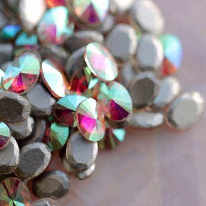 Side angle of oval AB zircons highlighting metallic silver base and multi-hued sparkle in pink, cyan, and magenta tones
