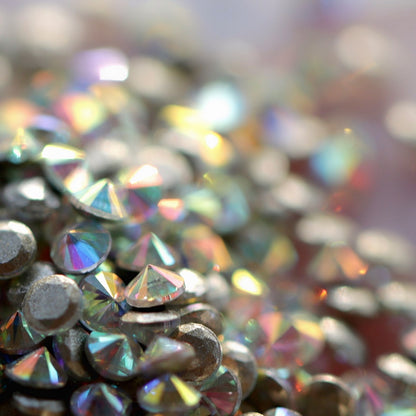 Close cluster of Rivoli round flatback crystals in AB finish displaying gold, pink, and blue light refractions