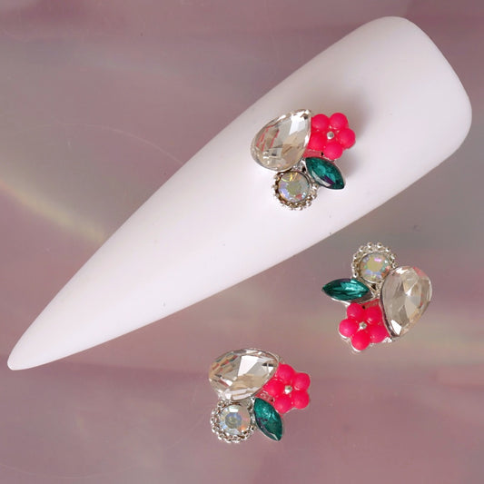 Floral nail charm featuring a large clear teardrop crystal, iridescent centre stone, bright pink flower, deep green leaf and silver-tone details. This elegant decoration is ideal for romantic manicures, floral nail art, bridal designs, summer looks and sparkling accent nails.