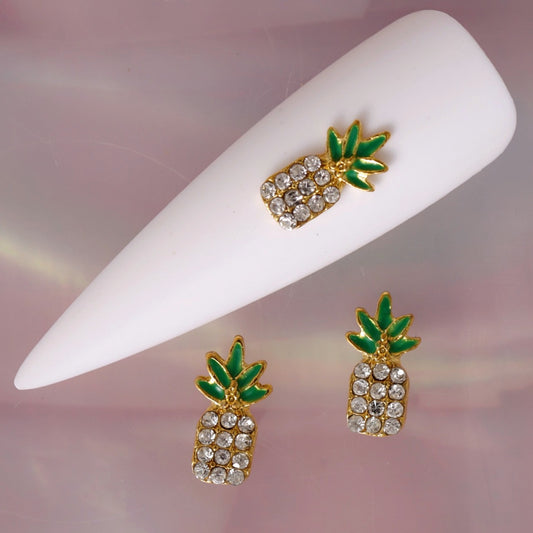 Tropical pineapple nail charm featuring a polished gold-tone outline, vivid green leaves and a pineapple body decorated with clear Crystal-coloured rhinestones. This glamorous summer decoration is ideal for tropical manicures, beach nail art, holiday designs and sparkling accent nails.