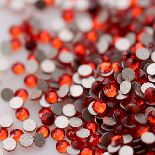Light Siam red K9 flatback rhinestones displayed from the front and back, highlighting their reflective faceted tops and flat backs for nail-art application.