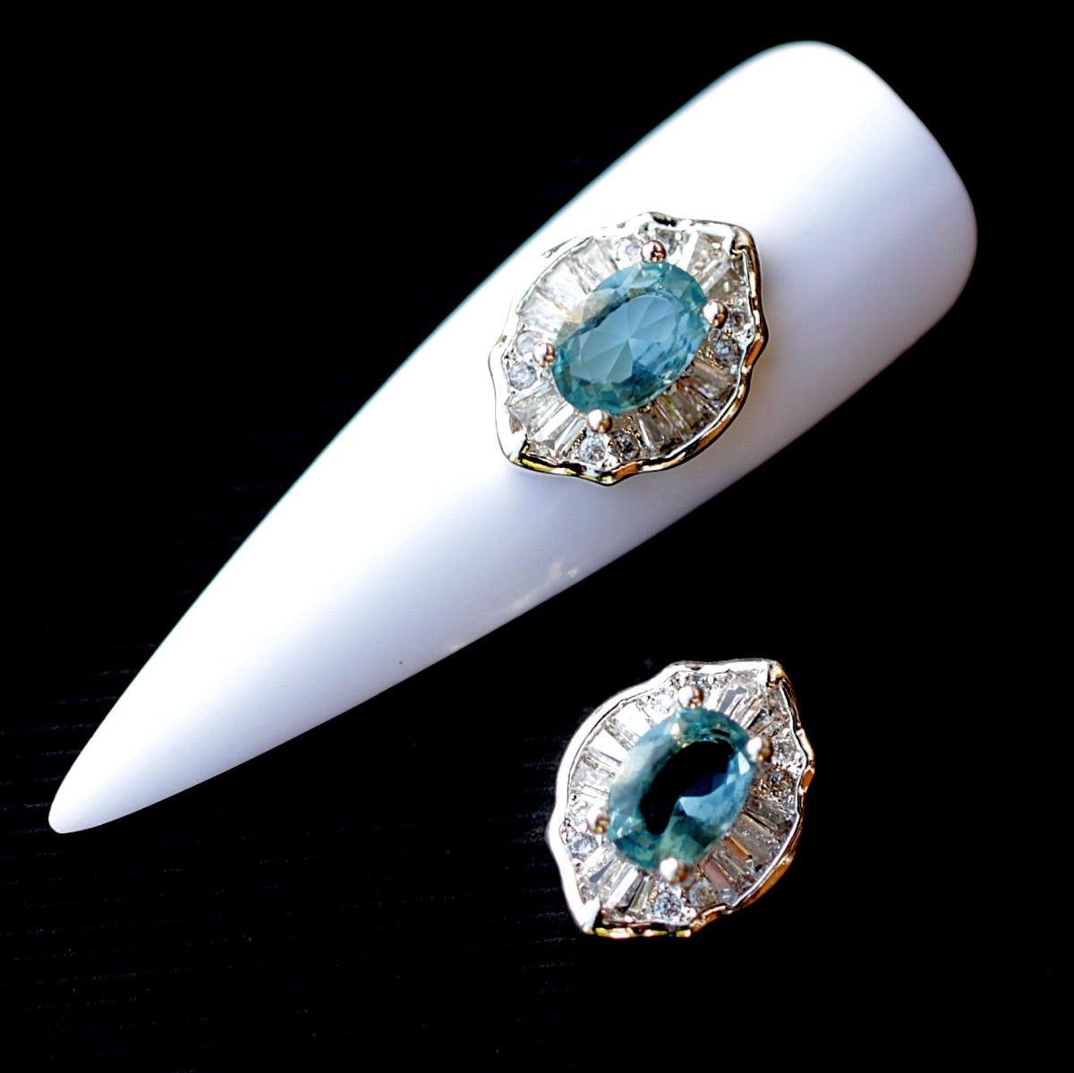 Large Crystal CZ nail charm featuring a vivid aquamarine oval centre crystal surrounded by clear baguette-shaped crystals and smaller transparent cubic zirconia accents. The framed jewellery-inspired decoration has a bright, dimensional appearance and is suitable for bridal manicures, ocean-inspired designs, mermaid nail art, evening looks and statement accent nails.