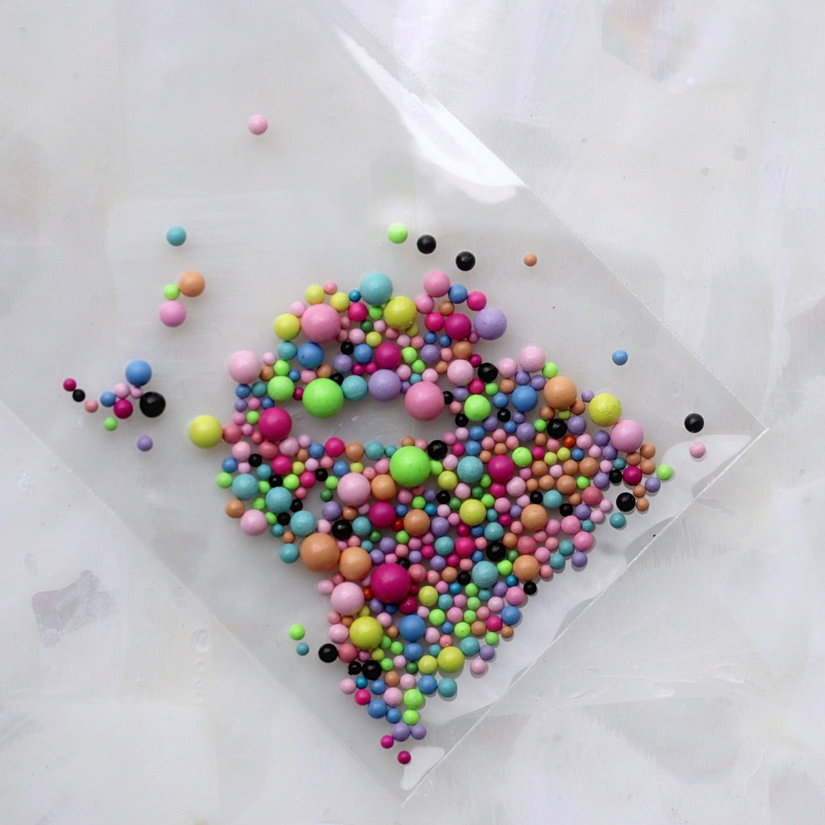 A colourful assortment of metallic-look round nail caviar beads in mixed sizes, including pink, blue, green, yellow, orange, purple, turquoise, brown and black shades. These versatile 3D nail-art decorations are ideal for textured manicures, colourful borders, abstract patterns, kawaii designs and creative accent nails.