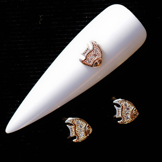 Fish-shaped nail charm with a shiny rose gold finish and tiny transparent cubic zirconia crystals arranged across the body. The decorative ocean-inspired nail jewellery piece is suitable for summer manicures, mermaid nail art, beach designs, romantic manicures and delicate accent nails.