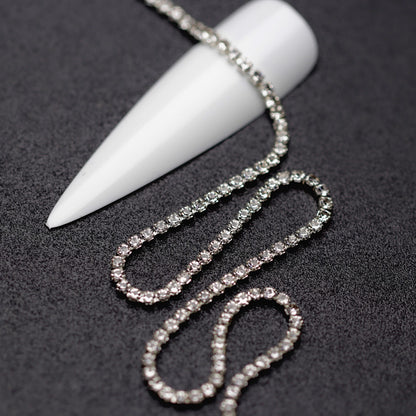 Close-up of silver 1.5 mm clear crystal rhinestone cup chain for nail art on black background