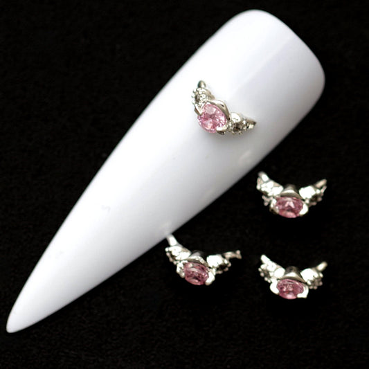 Silver 9×4 mm curved nail ring charms with central light rose CZ and small clear crystals displayed on a white nail tip against a dark background